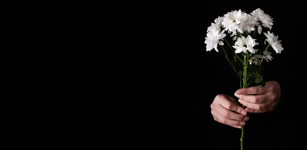 Hände halten einen Strauß weißer Margeriten