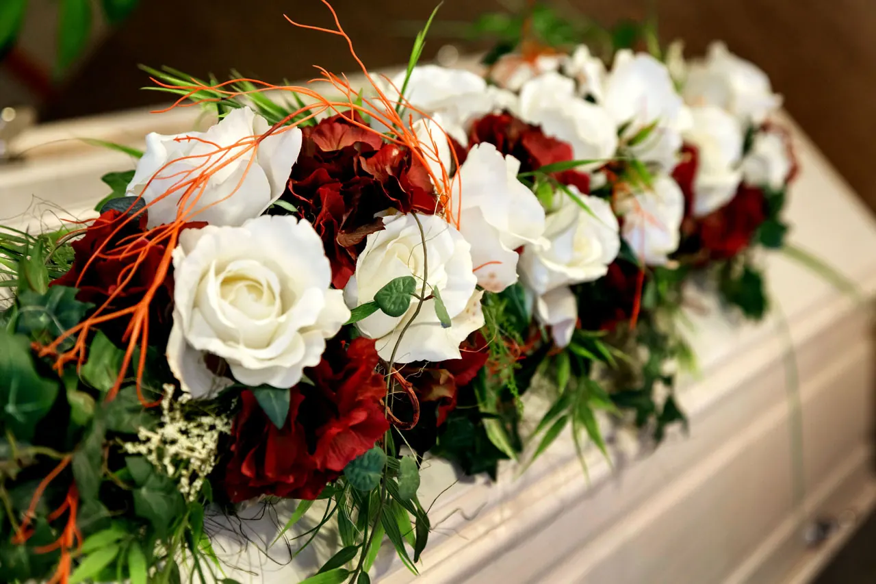 Weiße und rote Rosen als Sargschmuck