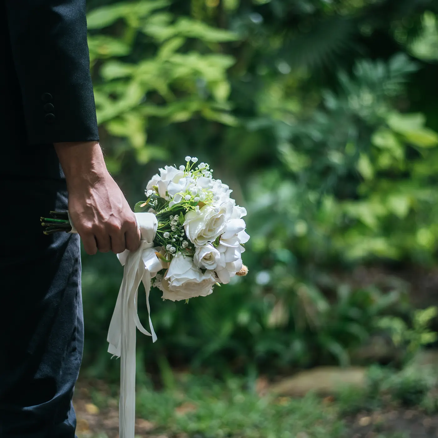 Trauernder mit weißem Blumenstrauß