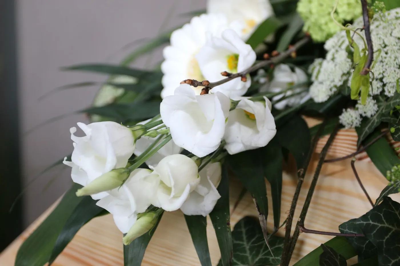 Weiße Blüten als Sargschmuck in Nahaufnahme