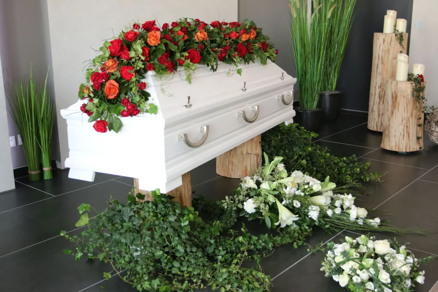 Weißer Sarg mit roten Rosen und Efeu