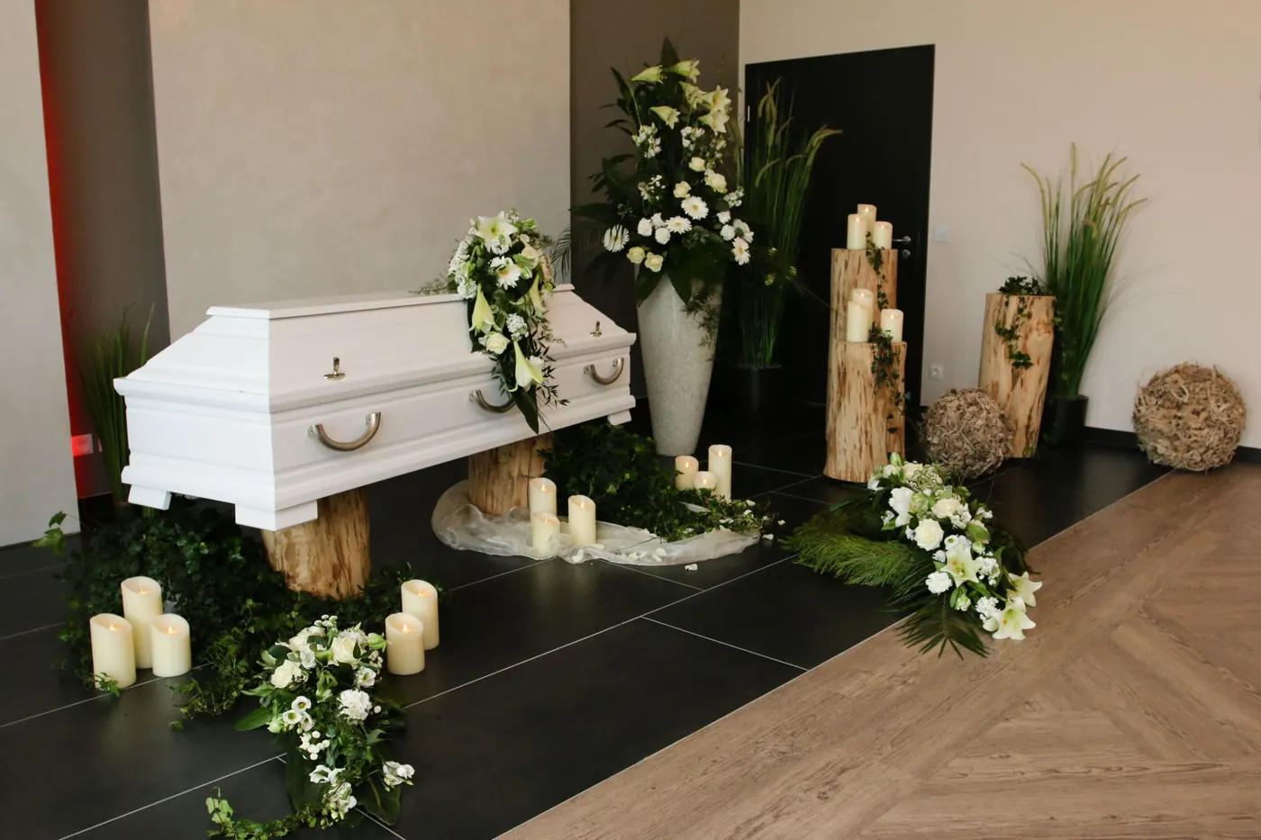 Weißer Sarg mit weißer Floristik und Kerzen