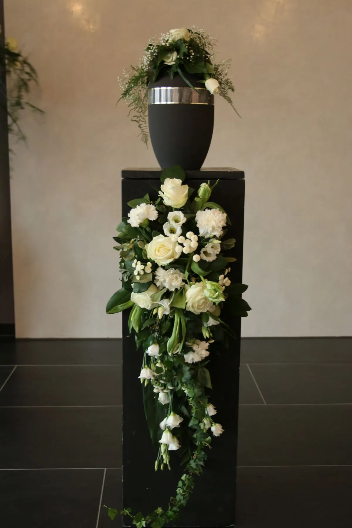 Urne auf Säule mit weißer Blumenkaskade